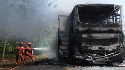 Petugas pemadam kebakaran berusaha memadamkan api yang melalap bus pariwisata nopol AB 7536 AK pada ruas tol Jagorawi arah Bogor di KM 36, Bogor, kamis (25/7/2019). Kebakaran bus ini menyebabkan kemacetan lalu lintas menuju Bogor. (merdeka.com/Arie Basuki)