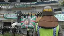 Polisi berjaga dekat Bonek yang memberi dukungan kepada timnya saat melawan PSIS Semarang pada laga perdana babak 8 besar Grup Y Liga 2 Indonesia di Stadion GBLA, Bandung, (15/11/2017). Persebaya menang atas PSIS Semang 1-0. (Bola.com/Ronald Seger)