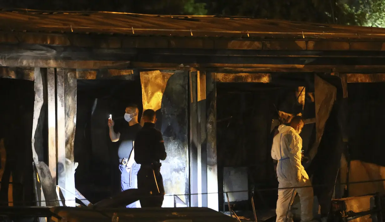 Petugas polisi dan forensik menyelidiki lokasi di rumah sakit darurat yang terbakar setelah kebakaran di kota Tetovo, Makedonia Utara, Kamis (9/9/2021). Kebakaran tersebut menewaskan sedikitnya 10 pasien. (AP Photo/Boris Grdanoski)