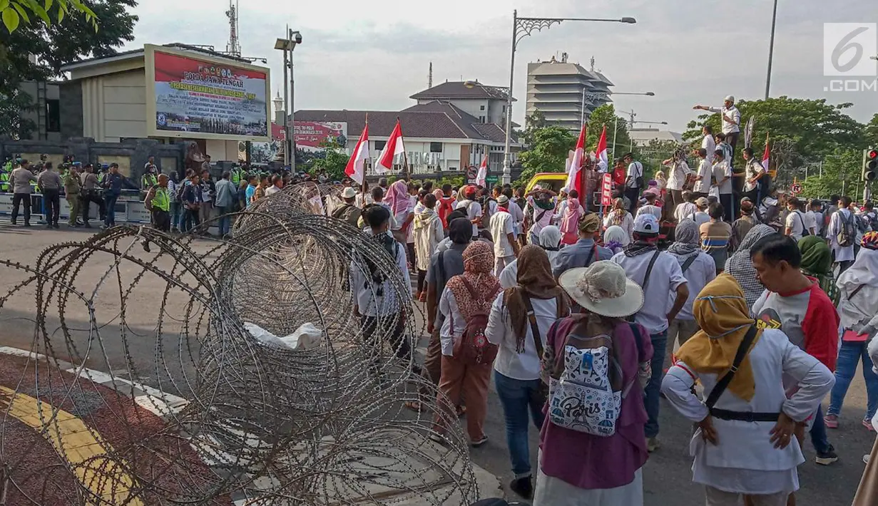 Petugas berjaga saat unjuk rasa ratusan massa di Perempatan Jalan Pahlawan Semarang,  Jumat (10/5). Mereka menuntut kejujuran penghitungan suara KPU pada Pemilu 2019. (Liputan6.com/Gholib)