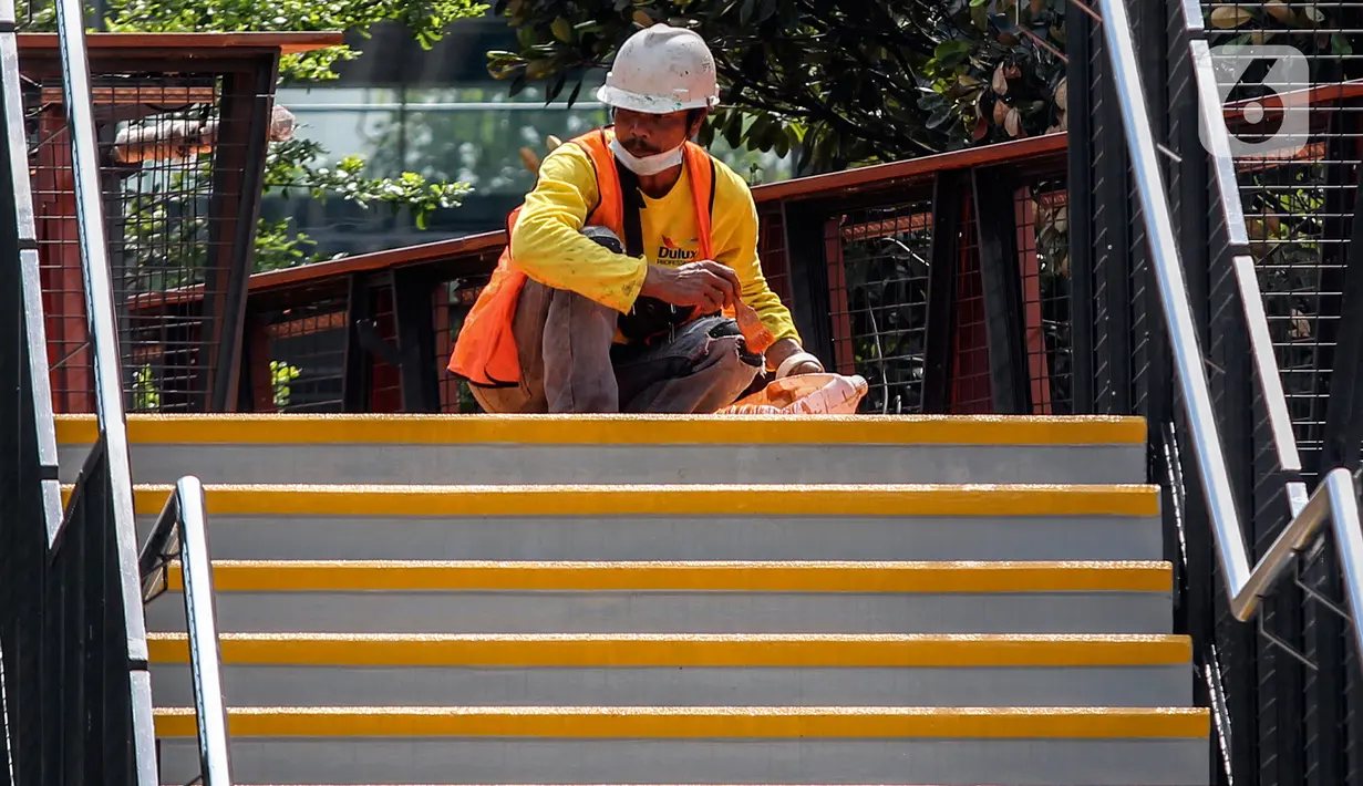 Aktivitas pengerjaan revitalisasi Jembatan Penyeberangan Orang (JPO) di Jalan Sudirman, Jakarta, Minggu (19/12/2021). JPO yang juga dilengkapi Anjungan Pandang Jakarta dan terintegrasi halte TransJakarta ini telah mencapai 95 persen dan akan dapat diakses pada akhir 2021. (Liputan6.com/JohanTallo)