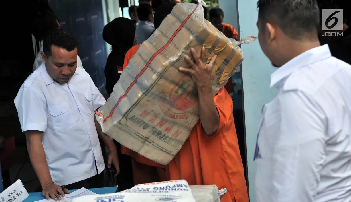 Tersangka mengangkut karung berisi paket narkoba sebelum dimusnahkan di Kantor BNN, Jakarta, Senin (10/12). Narkoba tersebut merupakan hasil penangkapan dari enam kasus selama November 2018. (Merdeka.com/Iqbal Nugroho)