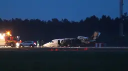 Layanan darurat terlihat di sebelah pesawat Cessna 560XL yang terbakar saat mendarat di Bandara Aarhus di Tirstrup (6/8/2019). Tidak ada korban jiwa akibat kecelakaan pesawat yang terbakar pada pukul 00.38 di malam hari. (Oexenholt Foto/Ritzau Scanpix/AFP)