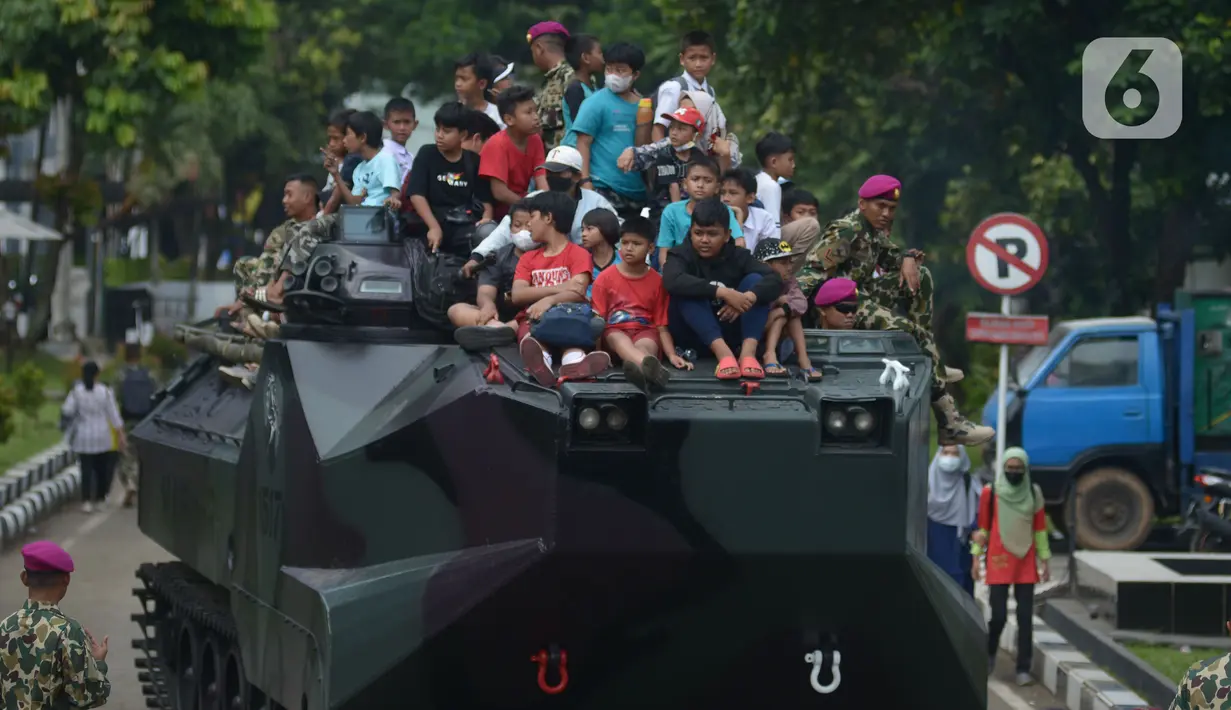 Warga naik tank berkeliling  di lapangan Marinir Cilandak, Jakarta, Selasa (15/11/2022). Kegiatan ini dilakukan dalam rangka peringatan HUT Ke-77 Korps Marinir dibuka untuk warga mencoba berkeliling markas Marinir. (merdeka.com/Imam Buhori)