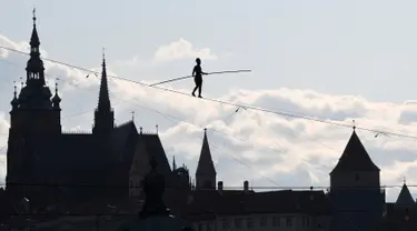 Aksi akrobat perempuan, Tatiana Mosio Bongonga, berjalan meniti tali melintas di atas sungai Vltava saat pembukaan Festival Sirkus dan Teater Internasional di Praha, Ceko, Rabu (14/8/2019). (Michal Cizek / AFP)