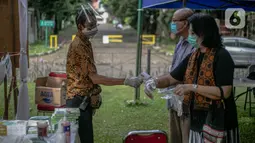 Petugas mengukur suhu warga sebelum memasuki TPS 69 Pisangan, Ciputat, Tangerang Selatan, Rabu (9/12/2020). pemungutan suara tersebut dengan menerapkan protokol kesehatan tersebut bertujuan untuk menghindari penularan COVID-19 pada pelaksanaan Pilkada 2020, serta menciptakan pemilu yang aman dan seh