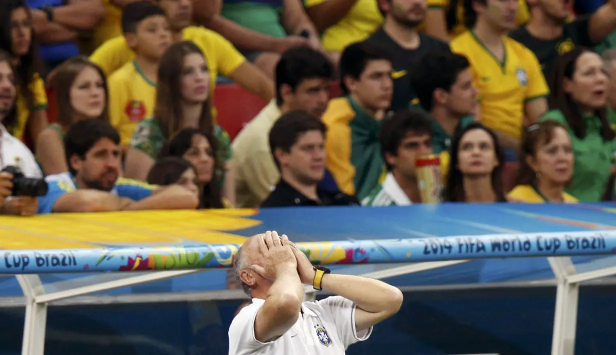 Pelatih Brasil, Luiz Felipe Scolari, menutup wajahnya menyaksikan tim asuhannya dipermalukan Belanda 0-3 di laga perebutan tempat ketiga Piala Dunia 2014 di Stadion Nasional Brasilia, (13/7/2014). (REUTERS/Ueslei Marcelino)