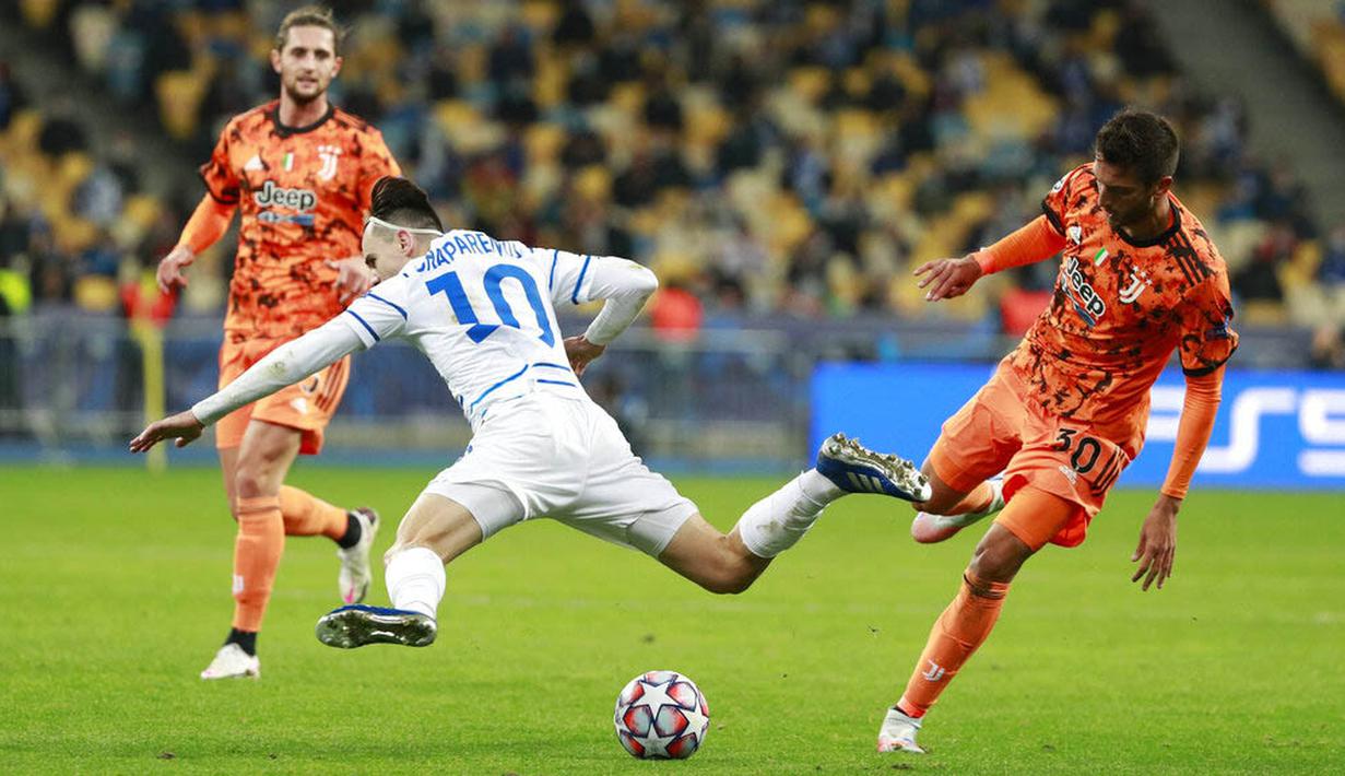 Pemain Juventus, Rodrigo Bentancur, berebut bola dengan pemain Dynamo Kyiv, Mykola Shaparenko, pada laga Liga Champions di Stadion Olimpiyskiy, Rabu (21/10/2020). Juventus menang dengan skor 2-0. (Valentyn Ogirenko/Pool via AP)