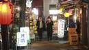 Orang-orang melintasi jalan di Tokyo, Jepang, Senin (25/10/2021). Orang-orang di Tokyo dapat makan dan minum di bar dan restoran mulai Senin malam ketika aturan jarak sosial dilonggarkan karena kasus COVID-19 harian di negara itu mencapai level terendah dalam setahun lebih. (AP Photo/Koji Sasahara)