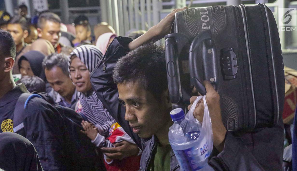 Pemudik mengangkut barangnya saat memasuki kapal penyebrangan menuju pelabuhan Bakauheni di Dermaga 1 Pelabuhan Penyebrangan Merak, Banten, Sabtu (1/6/2019). Hingga Sabtu (1/6) pukul 08.00 WIB, tercatat 400.309 orang menyebrang dari pelabuhan Merak menuju Bakauheni. (Liputan6.com/Helmi Fithriansyah)