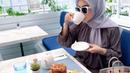 Selain berpose di pinggir jalan, Syahrini juga sempat menikmati momen tersebut di sebuah restoran. Begini gayanya saat minum teh hangat ditemani roti, masih menenteng tas Birkin Hermes-nya. (instagram.com/princessyahrini)