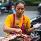 Seorang wanita memasak sate di gerobaknya di samping jalan di Bangkok, Thailand (20/9). Kota Bangkok, terkenal sebagai salah satu street food capital alias kota yang identik dengan makanan pinggir jalan. (AFP Photo/Jewel Samad)