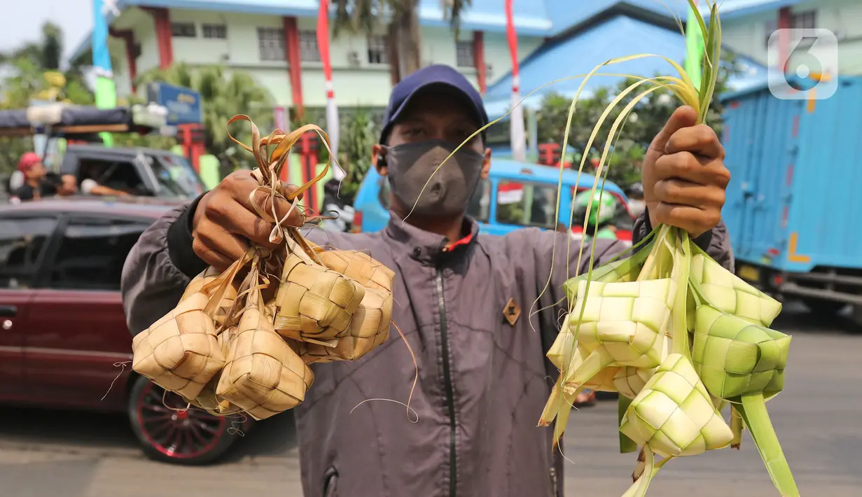 Pedagang menunjukkan kulit ketupat dan ketupat siap hidang di kawasan Cibubur, Jakarta, Rabu (30/7/2020). Pedagang musiman menjelang Idul Adha tersebut menjual kulit ketupat dengan harga Rp 10 ribu, sedangkan ketupat yang siap untuk dihidangkan seharga Rp 30 ribu. (Liputan6.com/Herman Zakharia)