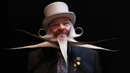 Seorang peserta berpose sebelum ambil bagian dalam Kejuaraan Jenggot dan Kumis Dunia 2019 di Antwerpen, Belgia pada 18 Mei 2019. Sejak 2001, kompetisi ini telah berkeliling mulai dari Inggris, Alaska, Norwegia, Jerman, Austria dan Texas, AS pada 2017. (REUTERS/Yves Herman)