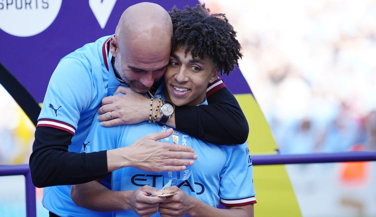 Pelatih Manchester City, Pep Guardiola, memeluk Rico Lewis saat perayaan gelar juara Liga Inggris di Stadion Etihad, Manchester (21/5/2023). (AP Photo/Jon Super)