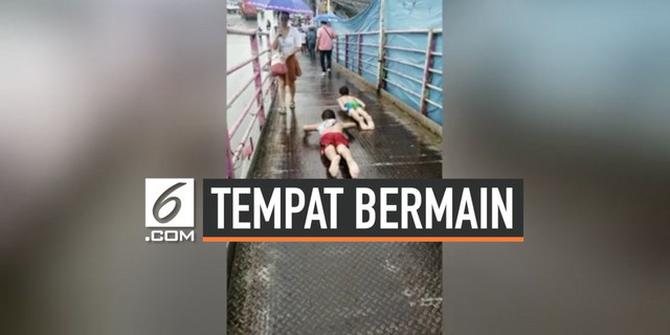 VIDEO: JPO Jadi Tempat Bermain Anak Saat Hujan