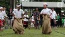 Anak-anak bersemangat mengikuti lomba balap karung usai mengikuti upacara peringatan detik-detik Proklamasi di halaman Tugu Pahlawan Banjar Penglipuran, Kabupaten Bangli, Bali, Kamis (17/8/2023). (Liputan6.com/Helmi Fithriansyah)