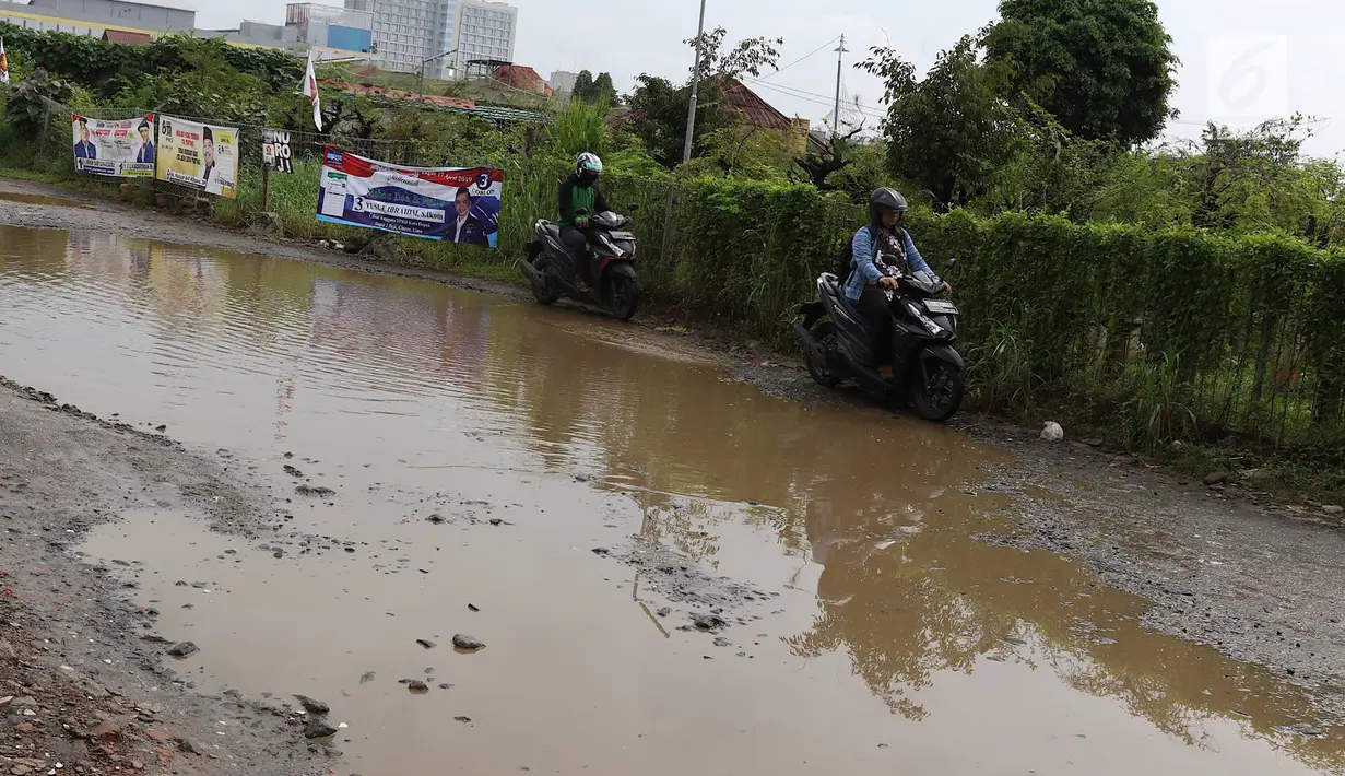 Kendaraan menghindari kubangan pada jalan yang rusak di Jalan Pertamina, Kemiri Muka, Depok, Jawa Barat, Selasa (5/3). Jalan rusak yang telah berlangsung bertahun-tahun tersebut tak kunjung diperbaiki. (Liputan6.com/Immanuel Antonius)