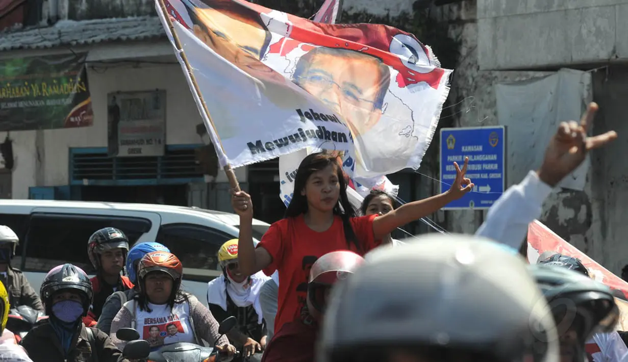 Seorang wanita simpatisan calon presiden pasangan nomor urut dua, Joko Widodo ikut berkonvoi dalam kampanye terbuka di kawasan Pasar Kota, Gresik, Jawa Timur, Minggu (29/6/14). (Liputan6.com/Herman Zakharia)