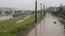 Sebuah kereta metropolitan terlihat di jalur rel yang banjir yang membentang di sepanjang sungai Pinheiros di Sao Paulo, Brasil, Senin, (10/2/2020). Hujan deras yang membanjiri kota, menyebabkan pinggir sungai utama meluap. (AP Photo/Andre Penner)