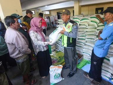 Keluarga Penerima Bantuan Pangan (PBP) antre untuk menerima Bantuan Pangan Non Tunai (BPNT) beras 20 kg di Kantor Kelurahan Rangkapan Jaya Baru, Depok, Jawa Barat, Kamis, (24/7/2025). (merdeka.com/Arie Basuki)