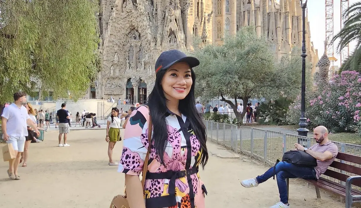 Sagrada Familia, merupakan mahakarya dari arsitek terkenal Antoni Gaudí, yang saat ini menjadi destinasi wajib dikunjungi para wisatawan di Barcelona. Katedral ini dikenal dengan desainnya yang unik dan rumit, mencerminkan kejeniusan dan imajinasi Gaudí. Titi Kamal tampak terpukau dengan keindahan dan detail arsitektur bangunan ini, seperti yang terlihat dalam beberapa foto yang dibagikannya di media sosial. (Liputan6.com/IG/@titi_kamall)