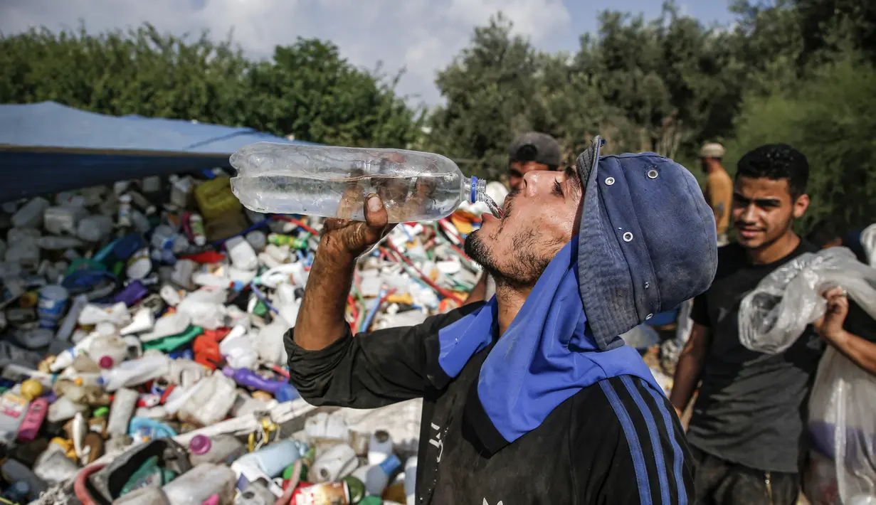 Seorang pengumpul sampah Palestina minum di tempat pembuangan sampah di Kota Gaza (29/7/2019). Kemiskinan yang terjadi akibat blokade Israel dan kurangnya kesempatan kerja membuat beberapa warga Palestina memilih bekerja mencari sampah untuk dijual. (AFP Photo/Mohammed)
