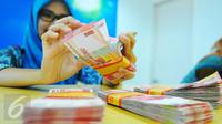 Petugas Bank tengah menghitung uang rupiah di Bank BRI Syariah, Jakarta, Selasa (28/2). Nilai tukar rupiah terhadap dolar Amerika Serikat (AS) melemah tipis pada perdagangan Selasa pekan ini. (Liputan6.com/Angga Yuniar)