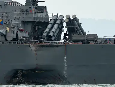 Lambung kiri kapal perang USS John S. McCain usai tabrakan dengan kapal tanker Alnic MC berbendera Liberia di Selat Malaka, sebelah timur Singapura, (21/8). Sepuluh pelaut hilang dan lima lainnya terluka akibat kejadian ini. (AFP Photo/Roslan Rahman)
