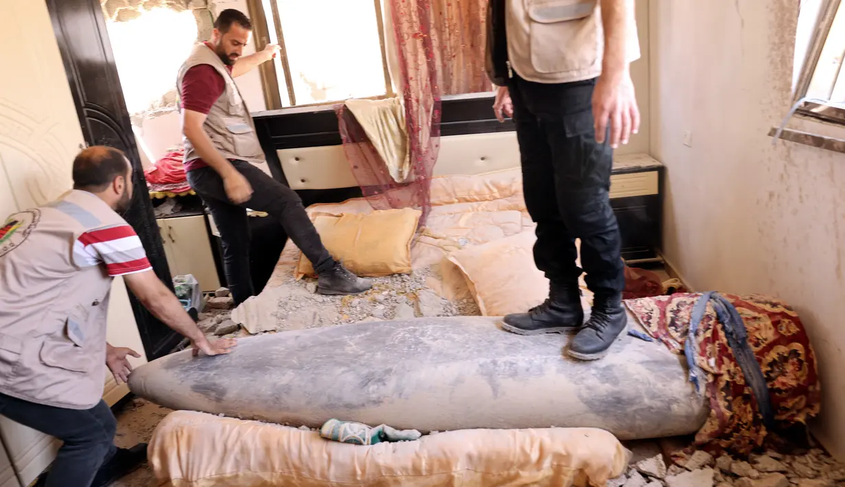 Pakar peledak Hamas saat sedang memeriksa rudal Israel yang tidak meledak setelah menghantam di sebuah rumah di Khan Yunis, Jalur Gaza selatan (20/5/2021). Dari sekian banyak rudal Israel yang meluncur dan meledak di Gaza, ada beberapa rudal yang tak meledak usai menghantam sasaran. (AFP/Said Khatib