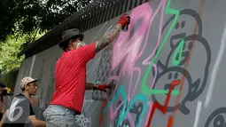 Seniman grafiti menyelesaikan karyanya selama festival Off The Wall di Kawasan Thamrin, Jakarta, Minggu (6/11). Acara ini memberikan perspektif baru terhadap seni urban sekaligus memperkenalkan para seniman Grafitti. (Liputan6.com/Gempur M. Surya)