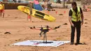 Ben Trollope bersiap menerbangkan drone pendeteksi hiu di Pantai Bilgola, utara Sydney, Australia, 10 Desember 2017. Drone ini dilengkapi megafon untuk memberi peringatan kepada perenang dan orang sekitar pantai tentang kehadiran hiu. (PETER PARKS/AFP)