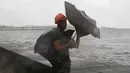 Seorang pria menahan payung yang tertiup angin kencang dan hujan ditengah cuaca buruk akibat Topan Nepartak yang menerpa kota Manila, Filipina, Jumat (8/7). (REUTERS/Erik De Castro)