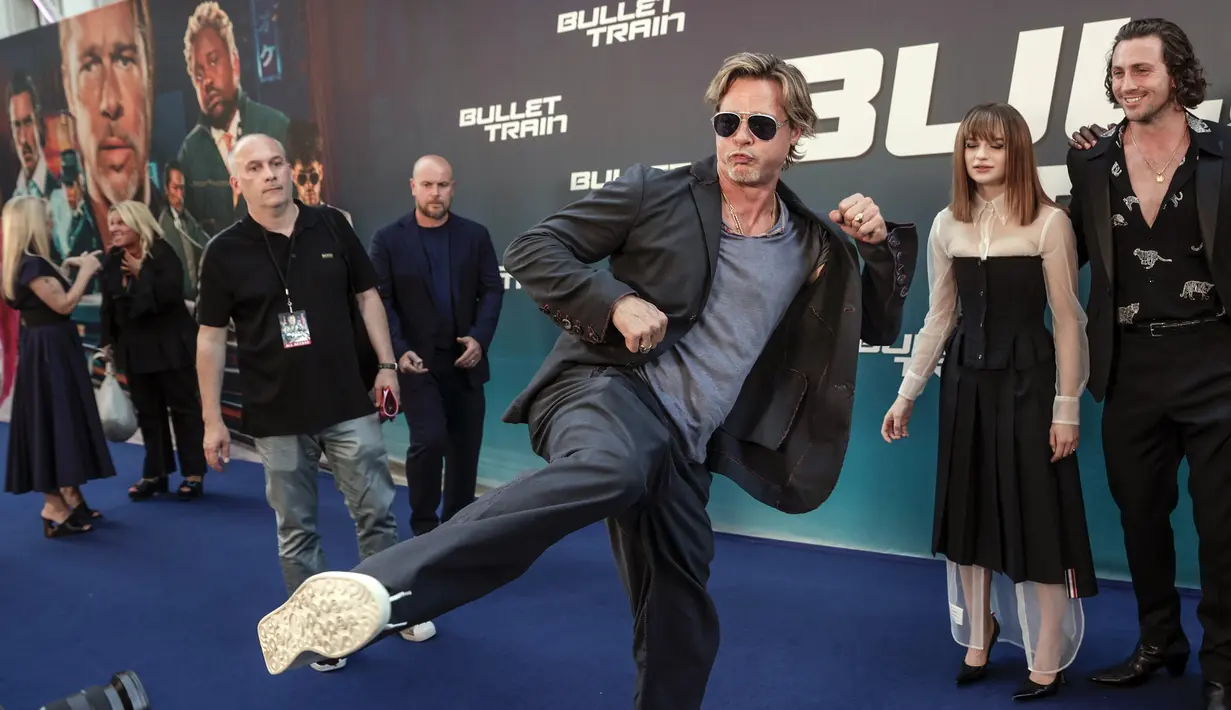 Brad Pitt bercanda dengan kameramen saat tiba pada pemutaran perdana film Bullet Train di Paris, Prancis, 18 Juli 2022. Brad Pitt menunjukkan penampilan energik saat dia menendang kakinya ke udara pada acara tersebut. (AP Photo/Lewis Joly)