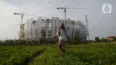 Petani menyemprot tanaman bayam dan kangkung di tanah garapan Taman BMW, Jakarta,Selasa (31/8/2021). Lahan kosong yang dirubah menjadi lahan produktif di samping proyek pembangunan Jakarta International Stadium (JIS) menjadi lahan pertanian sayur-sayuran. (merdeka.com/Imam Buhori)