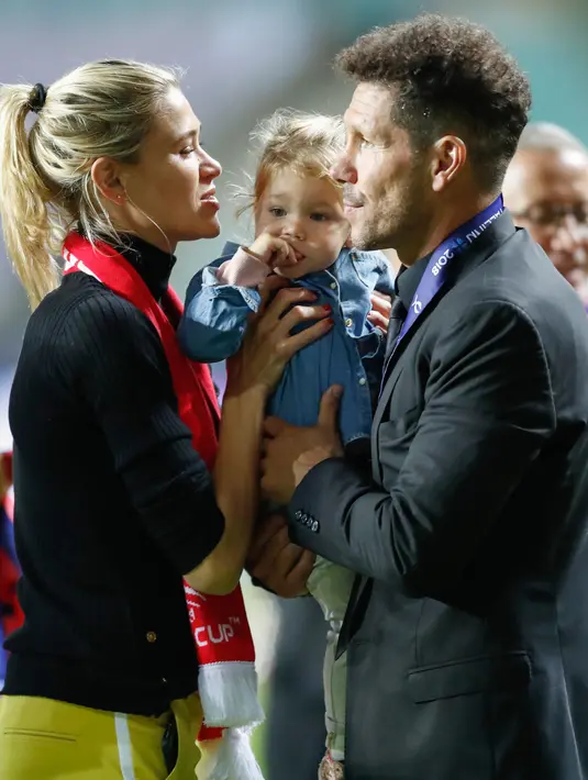 Pelatih Atletico Madrid, Diego Simeone bersama istri Carla Pereira dan putrinya Francesca saat berselebrasi meraih juara Piala Super Eropa setelah mengalahkan Real Madrid 4-2 di Lillekula Stadium di Tallinn, Estonia, (15/8). (AP Photo/Pavel Golovkin)