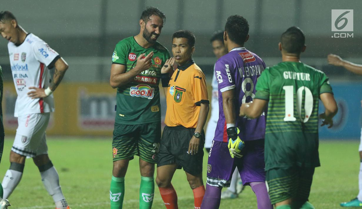 Pemain depan PS TNI, Elio Bruno Teixeira (kedua kiri) melakukan protes kepada wasit Untung saat laga melawan Bali United dilanjutan Liga 1 Indonesia di Stadion Pakansari, Kab Bogor, Senin (10/7). Bali United unggul 4-3. (Liputan6.com/Helmi Fithriansyah)