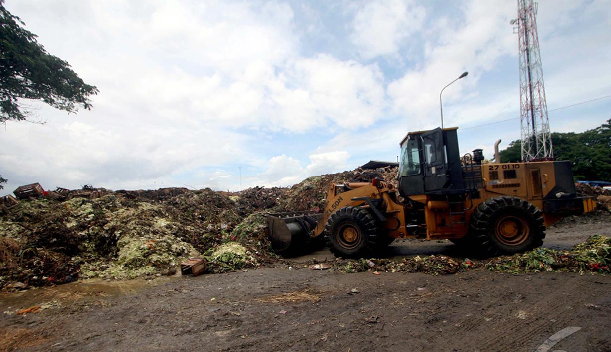 Petugas membersihkan sampah yang menggunung dengan mengunakan alat berat  di Pasar Induk Kramat Jati, Jakarta, Kamis (8/1/2015). (Liputan6.com/Faizal Fanani)