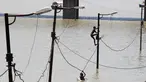 Warga memanjat tiang listrik saat terjebak banjir di tepi sungai Gangga, Allahabad, India, (21/8). Banjir bandang menerjang sejumlah wilayah di India yang menyebabkan banyak warga yang terjebak. (REUTERS/Jitendra Prakash)