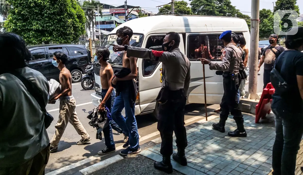 Aparat kepolisian mengamankan sejumlah remaja yang berkumpul di Kawasan Palmerah, Jakarta, Kamis (8/10/2020). Dari hasil pemeriksaan, mereka turun ke jalan karena mendapatkan undangan dari media sosial untuk melaksanakan aksi unjuk rasa di sekitar DPR. (Liputan6.com/Faizal Fanani)