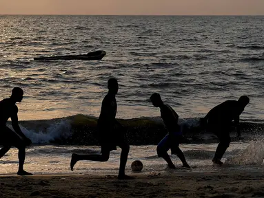 Anak-anak muda Gabon bermain sepak bola di tepian pantai  di Libreville (17/1/2017). Demam Piala Afrika 2017 menjadikan Gabon sebagai salah satu tujuan wisata sekaligus ajang mencari bakat-bakat muda Afrika.  (AFP/Gabriel Bouys)