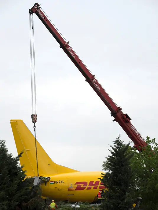 Petugas melakukan evakuasi pada pesawat kargo DHL yang tergelincir di landasan pacu di bandara Orio al Serio, Milan, Italia (5/8). Beruntung insiden ini tidak memakan korban jiwa, namun pesawat mengalami kerusakan parah. (REUTERS)