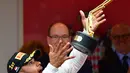 Pembalap Lewis Hamilton melemparkan piala saat melakukan selebrasi usai berhasil menjuarai Grand Prix di Monaco, (29/5). Hamilton menjadi yang tercepat dengan mencatatkan waktu satu jam 59 menit 29,133 detik. (AFP PHOTO/ANDREJ ISAKOVIC)