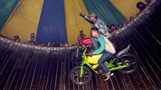 Pengendara motor melakukan akrobat 'Tong setan' di pasar malam PURI BETA II, Tangerang , Banten, Kamis (31/12). Acara ini untuk menghibur masyarakat yang ingin menghabiskan malam tahun baru. (Liputan6.com/Helmi Afandi)