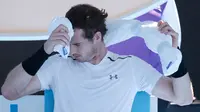 Petenis asal Inggris, Andy Murray meletakkan handuk berisi es di keningnya saat istirahat dalam pertandingan Australia Terbuka di Melbourne, Australia, (22/1). Teriknya cuaca di Australia Terbuka, membuat para pemain kepanasan. (AP Photo/Aaron Favila)
