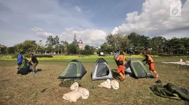 Petugas Penanganan Prasarana dan Sarana Umum (PPSU) mendirikan tenda saat persiapan untuk doa bersama pada malam Tahun Baru di Cipinang Melayu, Jakarta, Minggu (30/12). (Merdeka.com/ Iqbal S. Nugroho)