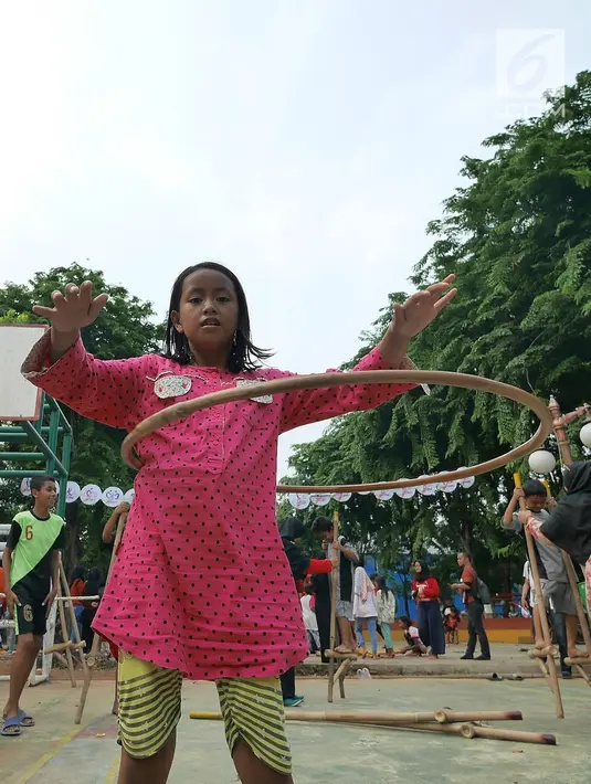 Seorang anak bermain permainan tradisional lenggang rotan di RPTRA Melati Duri Pulo, Jakarta, Sabtu (13/10). Traditional Games Returns (TGR) mengampanyekan permainan tradisional Indonesia untuk membangkitkan eksistensinya. (Liputan6.com/Herman Zakharia)