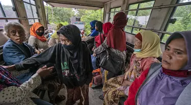 Warga  naik truk saat dievakuasi dari rumah mereka setelah letusan Gunung Merapi di Sleman, Yogyakarta (27/1/2021). Puluhan orang, sebagian besar lansia, tinggal dalam jarak beberapa kilometer dari kawah paling aktif di negara itu telah dievakuasi ke barak yang didirikan. (AP Photo/ Kasan Kurdi)