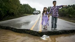 Duar Orang anak saat melihat jalanan yang rusak akibat Tornado yang menyaou bagian kota Texas, Amerika Serikat, Jumat (30/10/2015). Akibat peristiwa sudah lebih dari 20 orang tewas sejak Mei lalu. (REUTERS/Ilana Panich - Linsman)