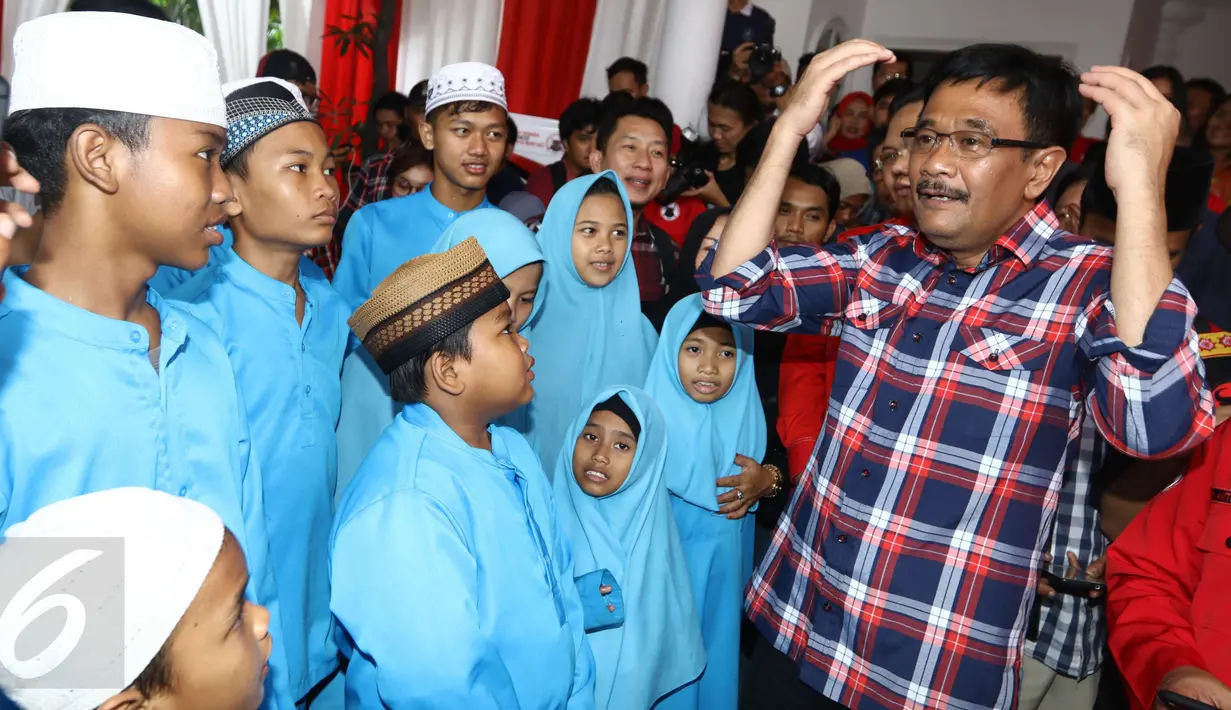 Calon wakil gubernur DKI, Djarot Saiful Hidayat bercengkerama dengan anak-anak saat menunggu Ketum PDIP, Megawati Soekarnoputri dalam acara HUT Banteng Muda Indonesia (BMI) ke-17 di Posko BMI, Menteng, Jakarta, Kamis (30/3). (Liputan6.com/Helmi Afandi)